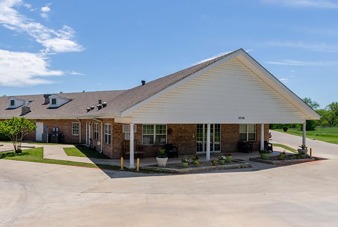 A commercial building with a driveway under a clear blue sky.