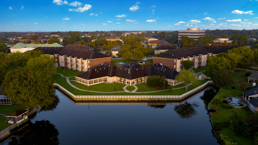 A serene waterfront property showcasing elegant architecture and lush green landscaping.