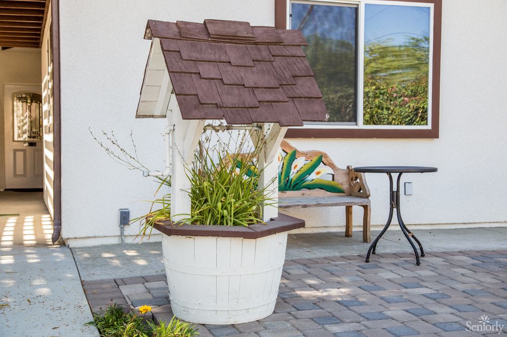 A decorative garden well with plants on a patio.