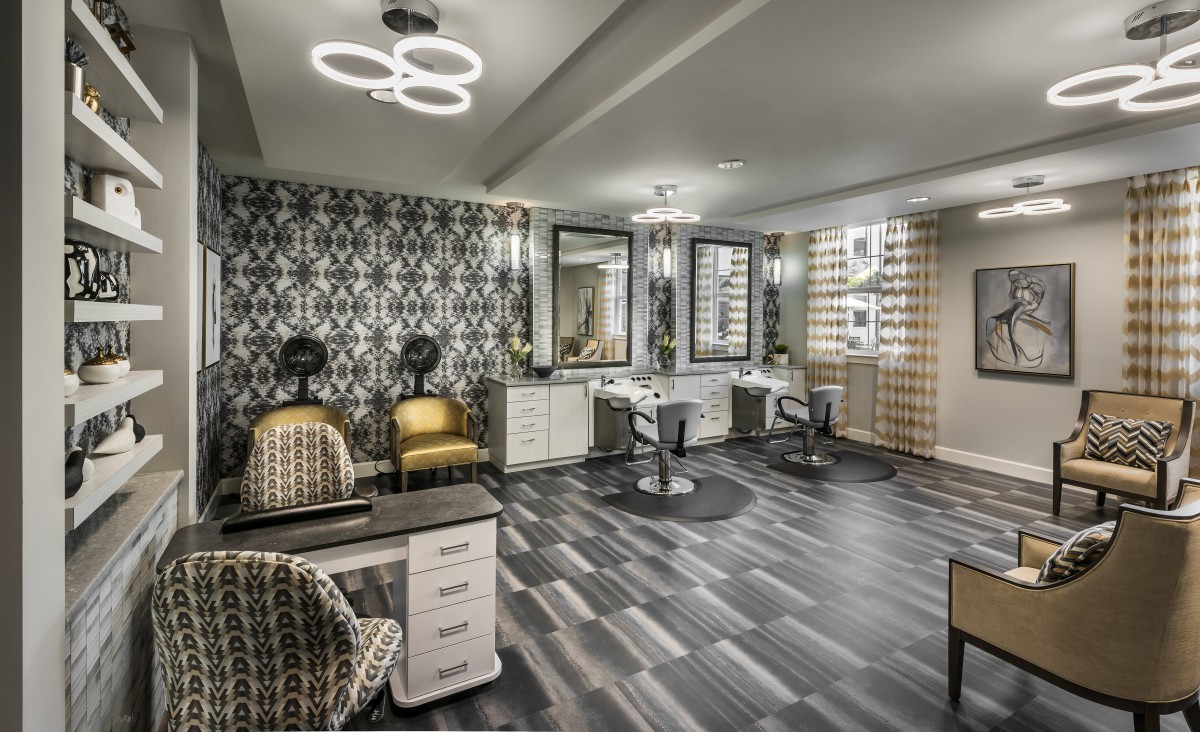 A modern salon with stylish decor, featuring hairdressing stations and seating.