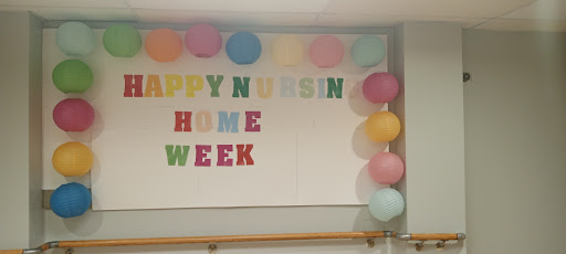 A festive display celebrating Nursing Home Week with colorful letters and balloons.