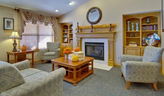 A cozy living room with a fireplace and autumn-themed decorations.