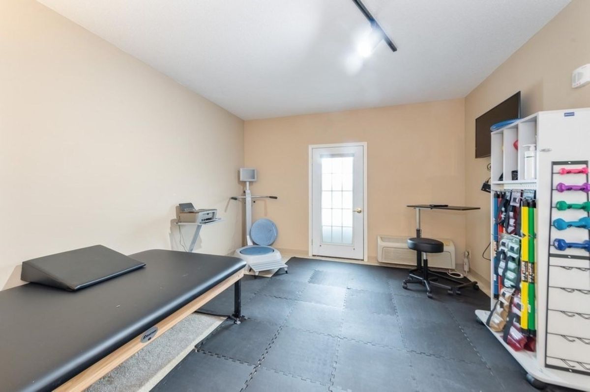 A home gym with various fitness equipment and minimalist decor.