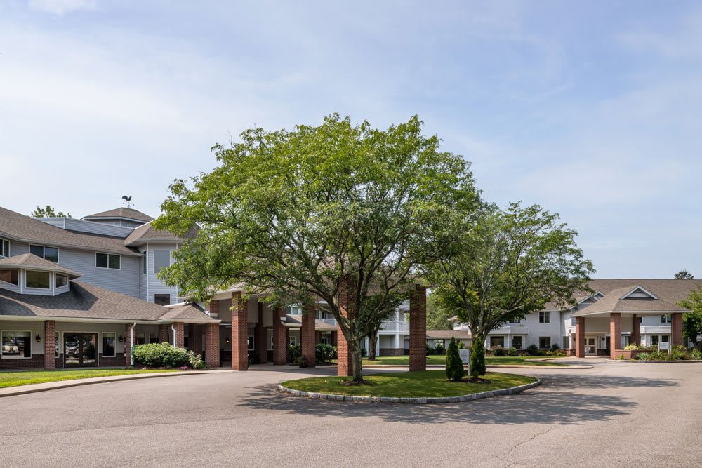 A view of a residential building surrounded by trees with a clear sky.