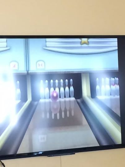 A virtual bowling game showing a bowling ball about to hit the pins.