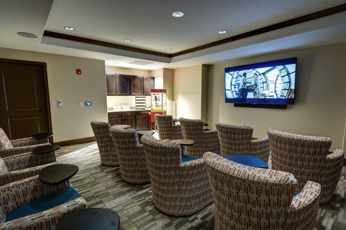 A cozy home theater room with comfortable seating and a large screen.