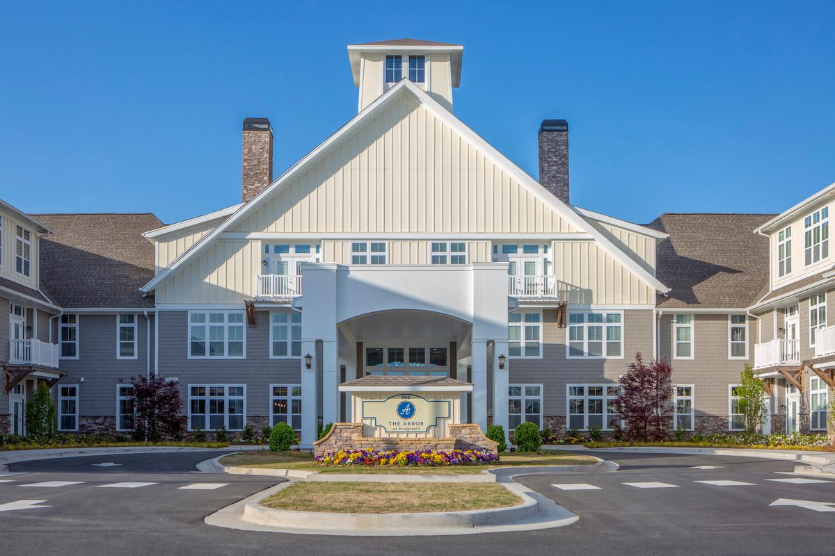 A modern residential building with a prominent entrance and well-maintained landscaping.