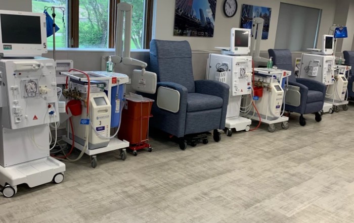 A healthcare facility's dialysis treatment area with medical machines and chairs.