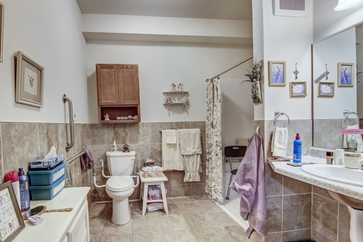 A tidy and well-equipped bathroom with a toilet, shower, and various accessories.