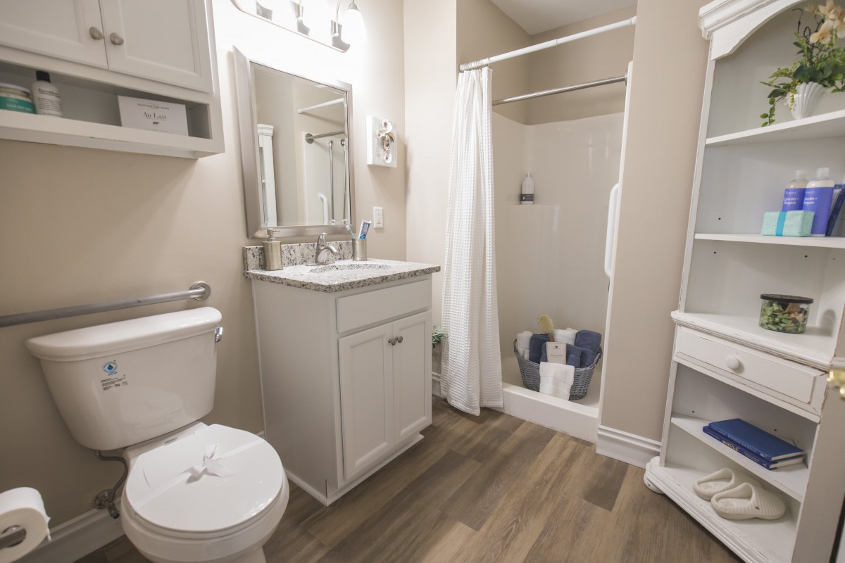 A modern bathroom with a shower, sink, and toilet.