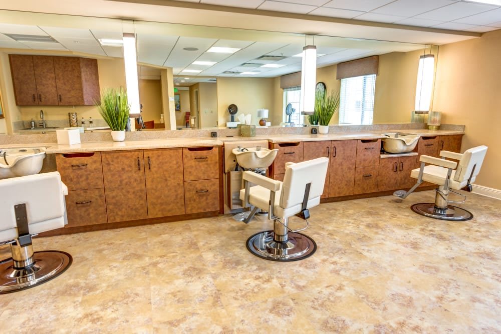 A modern salon interior featuring barber chairs, large mirrors, and wooden cabinets.