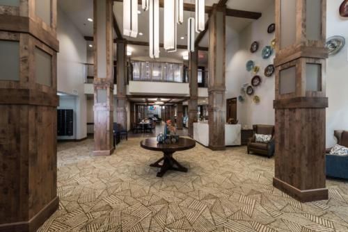 Modern hotel lobby with stylish chandeliers and seating area.