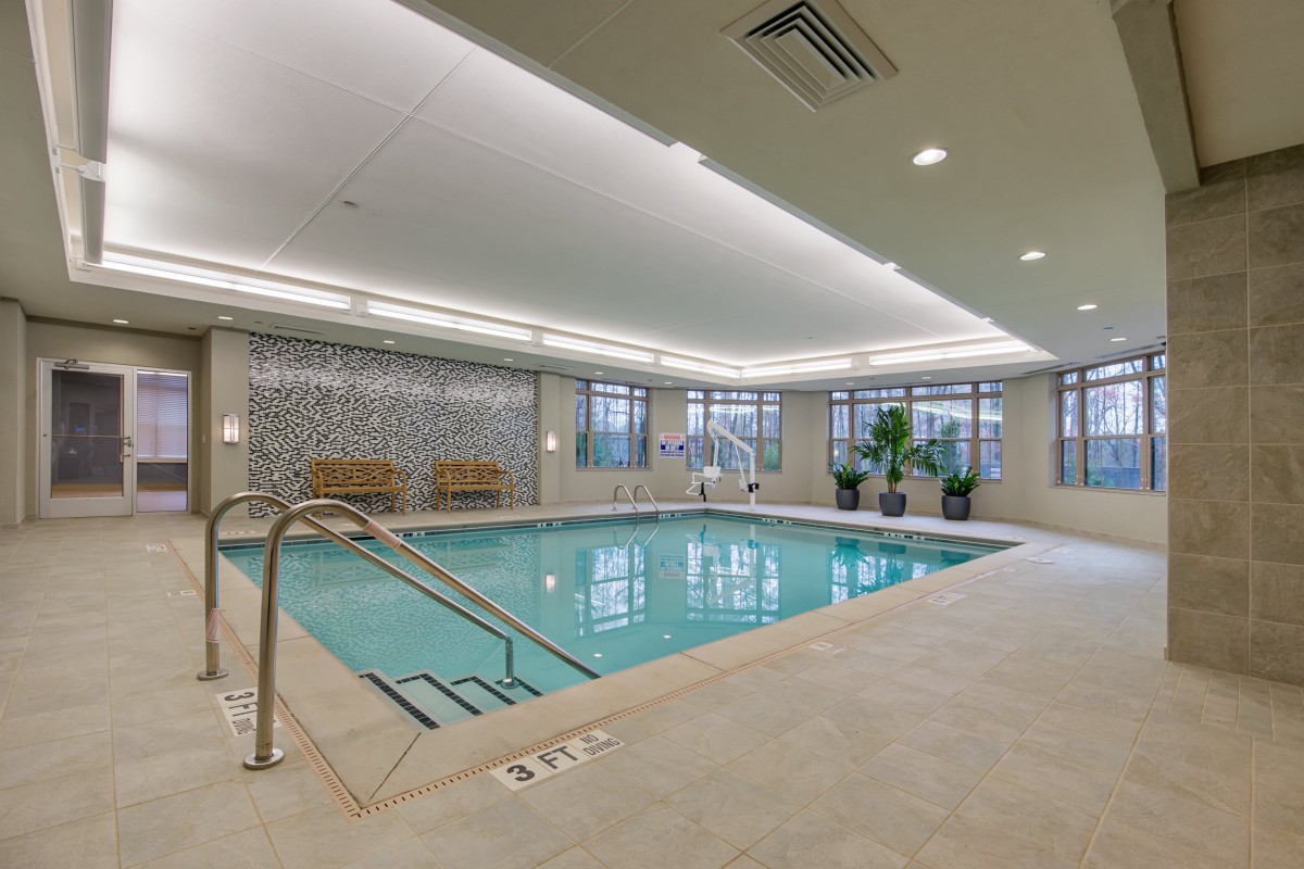 A well-lit indoor swimming pool with clean surroundings and modern amenities.