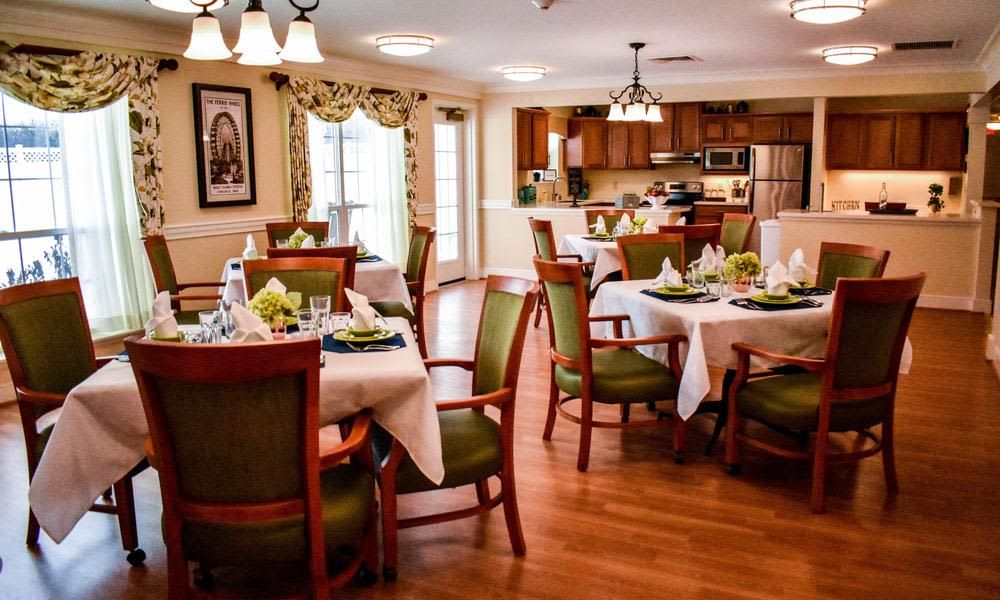A beautifully decorated dining area with elegant table settings and a view of the kitchen.