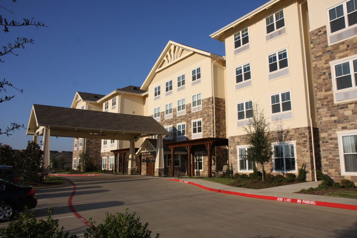 A modern senior living facility with a welcoming entrance and multiple floors.