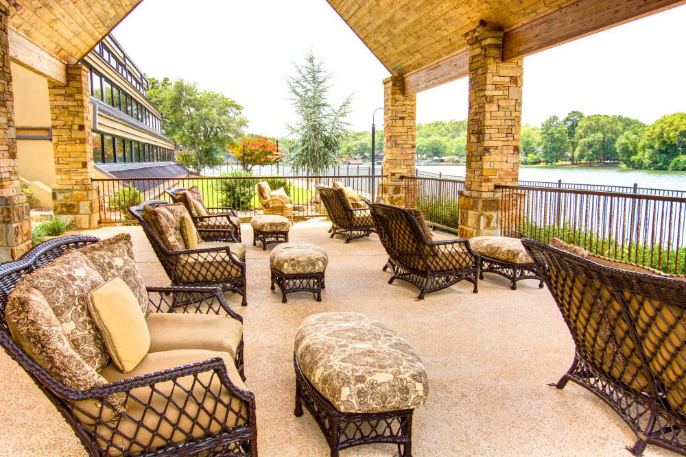 A cozy outdoor patio with comfortable seating and a scenic lake view.