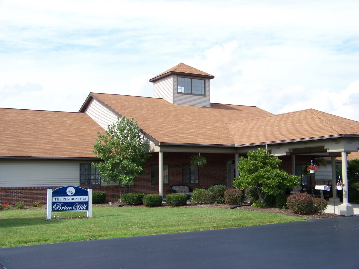 A healthcare clinic building with a prominent sign and well-maintained landscaping.