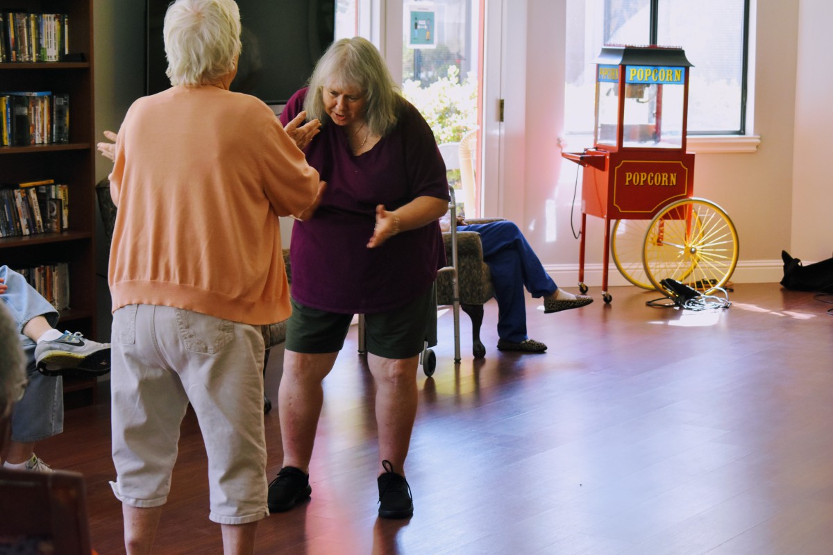 Elderly individuals enjoying a dance session indoors.