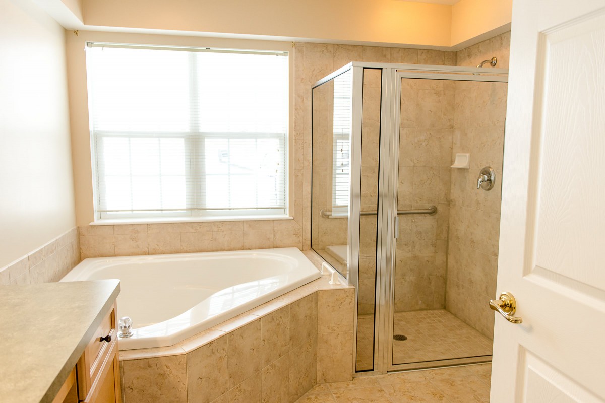 A modern bathroom featuring a separate bathtub and glass-enclosed shower.