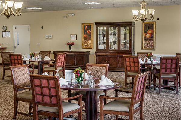 Elegant dining area with neatly arranged tables and chairs, featuring a classic decor style.