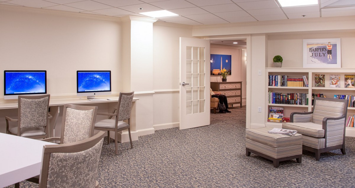A well-lit office space with a computer workstation and comfortable seating.