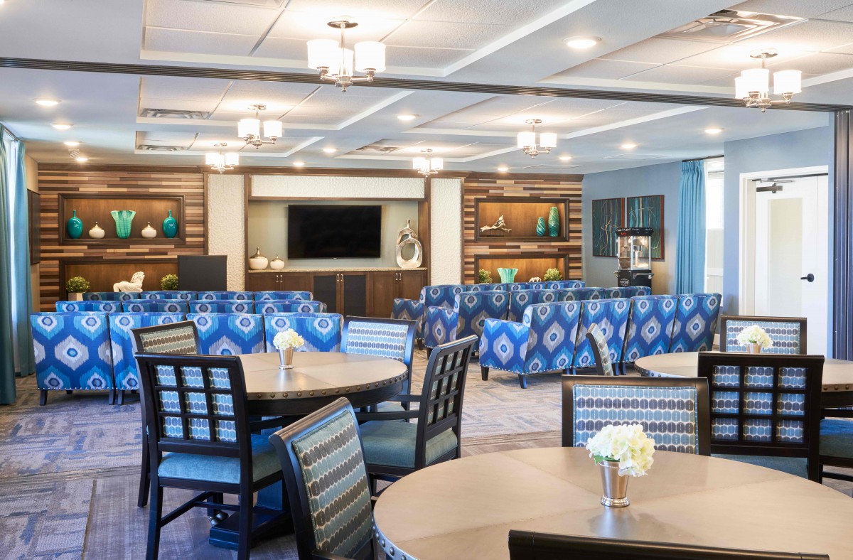 A stylish and comfortable lounge area with tables, chairs, and blue patterned couches.