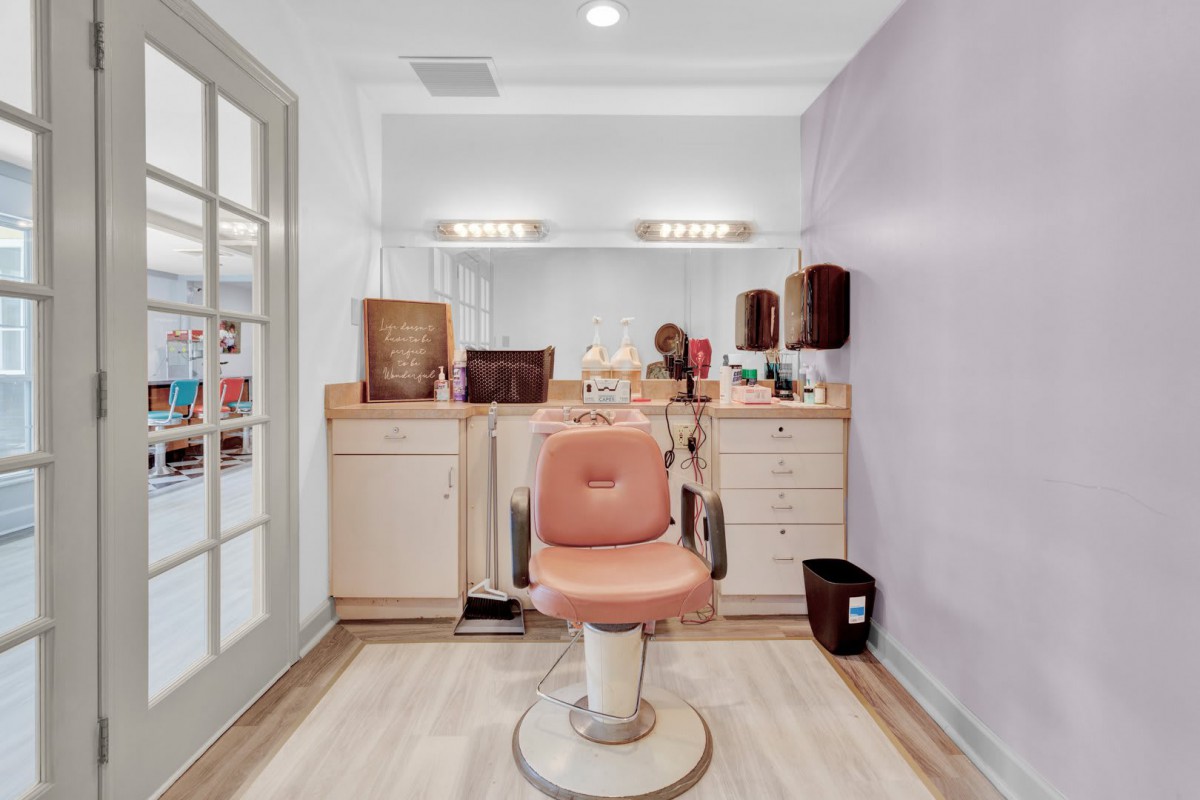 A well-organized salon with a central barber chair and neatly arranged styling tools.