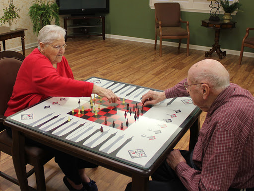 An elderly couple enjoying a game of checkers together, showcasing the joy of companionship and strategy.