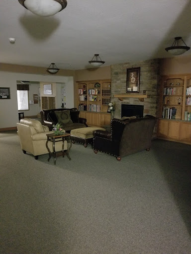 A cozy living room featuring a mix of comfortable seating and a bookshelf.