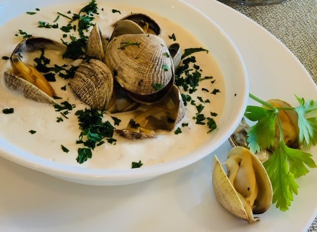 A creamy clam dish garnished with fresh herbs.