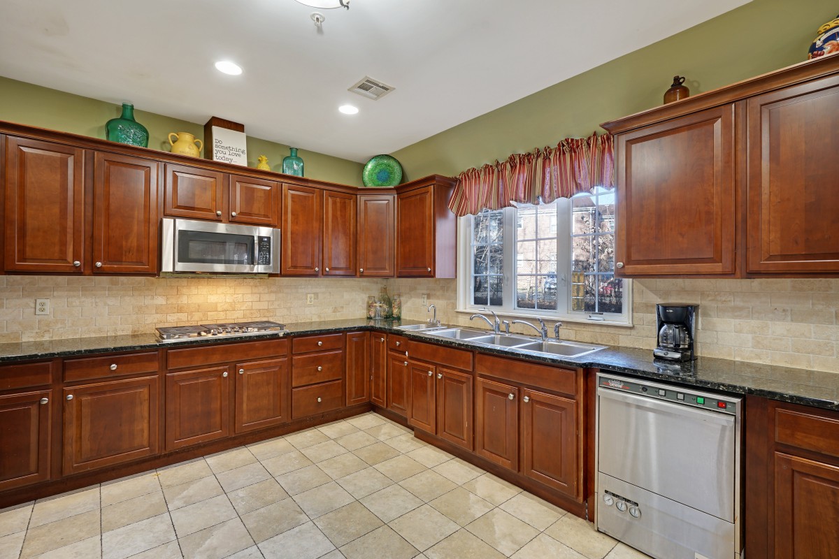 A spacious kitchen with wooden cabinets and modern appliances.