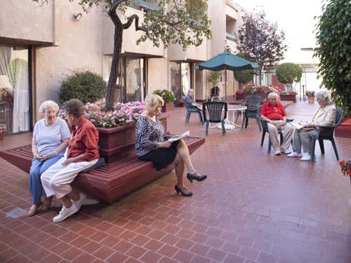 Seniors enjoying a conversation in an outdoor seating area.