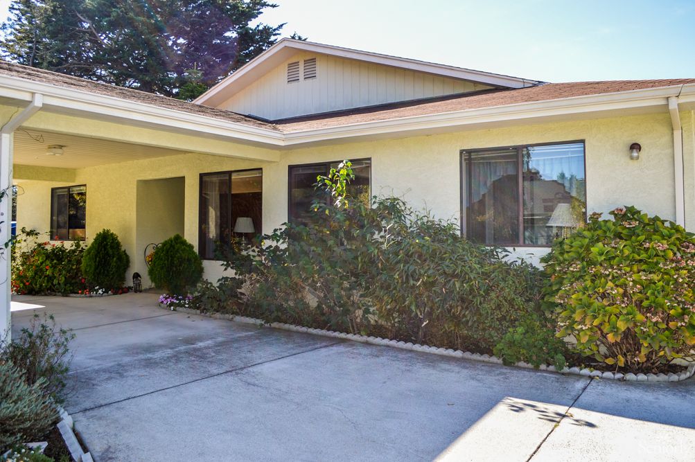 A suburban single-story house with a driveway and small garden.