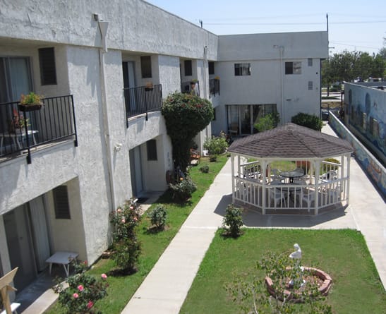 A residential building with a central courtyard featuring a gazebo and landscaped garden.