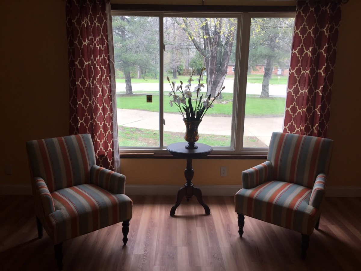 A cozy sitting area with striped chairs and a small table by the window.