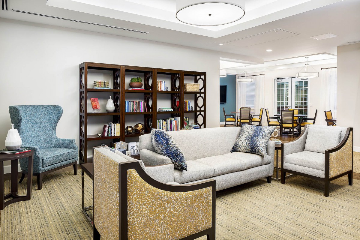 A modern living room interior with a cozy sofa, stylish bookshelf, and elegant lighting.