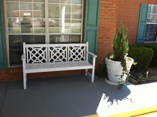 A charming outdoor scene featuring a white bench and potted plants.