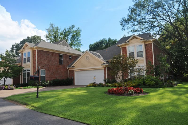 A suburban house with a neatly maintained lawn and a driveway.