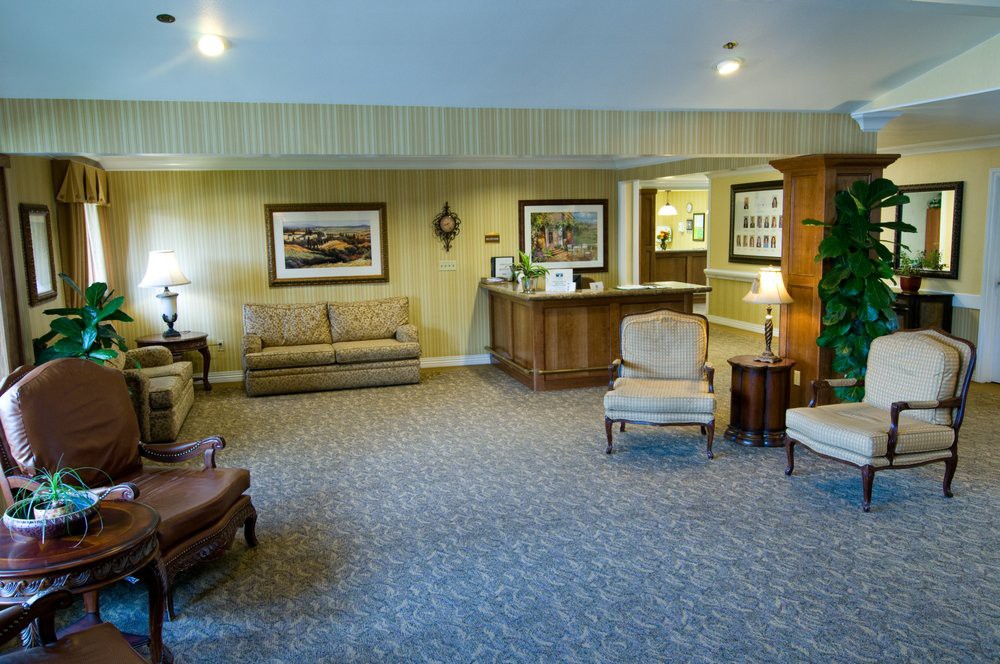 A cozy lobby area featuring sofas, chairs, and a reception desk.