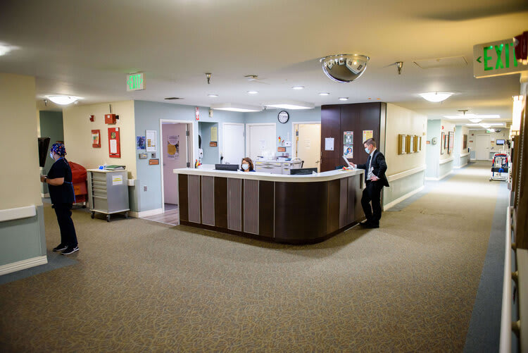A hospital reception area with a front desk and corridor.