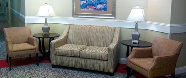 A cozy living room area with a striped sofa, side tables, and lamps.