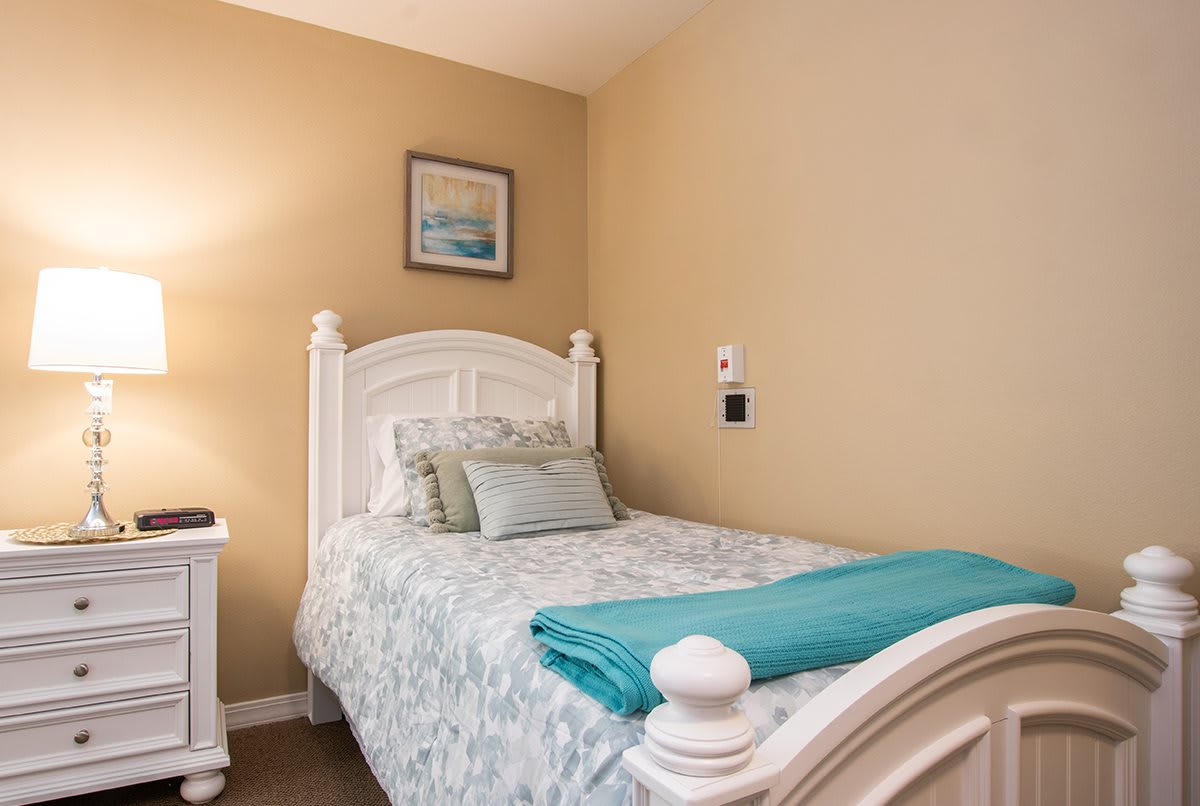 A cozy bedroom with a single bed and soft lighting.