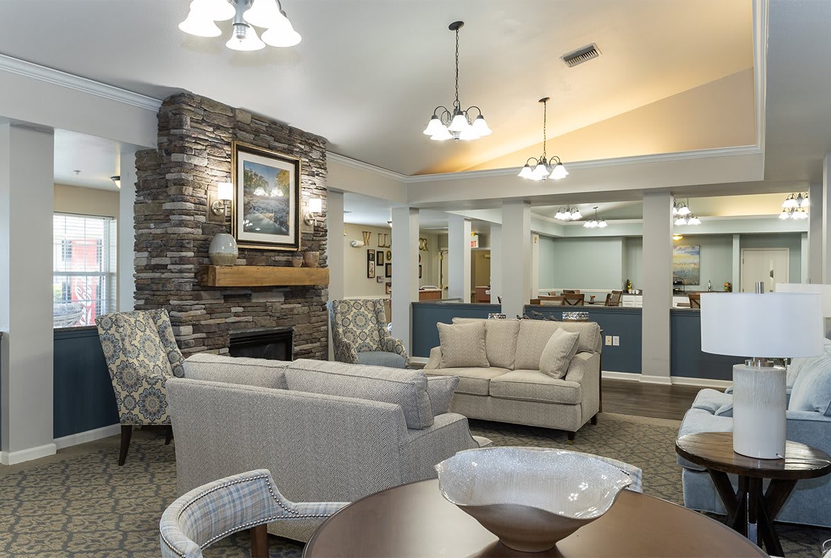 A cozy living room with modern decor, featuring comfortable sofas and a stone fireplace.