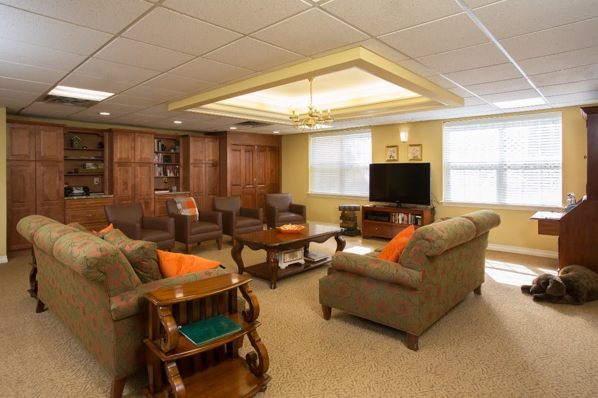 A cozy living room featuring comfortable seating, a television, and warm wood accents.