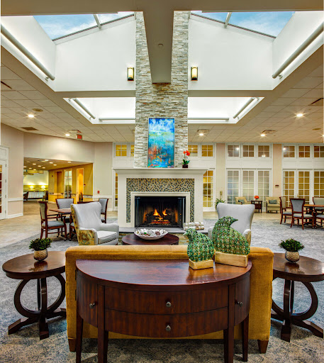 A spacious and elegantly designed lobby area featuring modern furniture, a cozy fireplace, and abundant natural light.