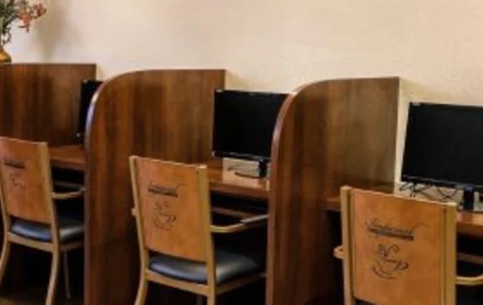 Wooden study cubicles with computers in a library setting.