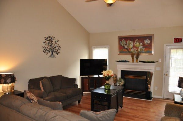 A cozy living room featuring a fireplace, television, and comfortable seating.