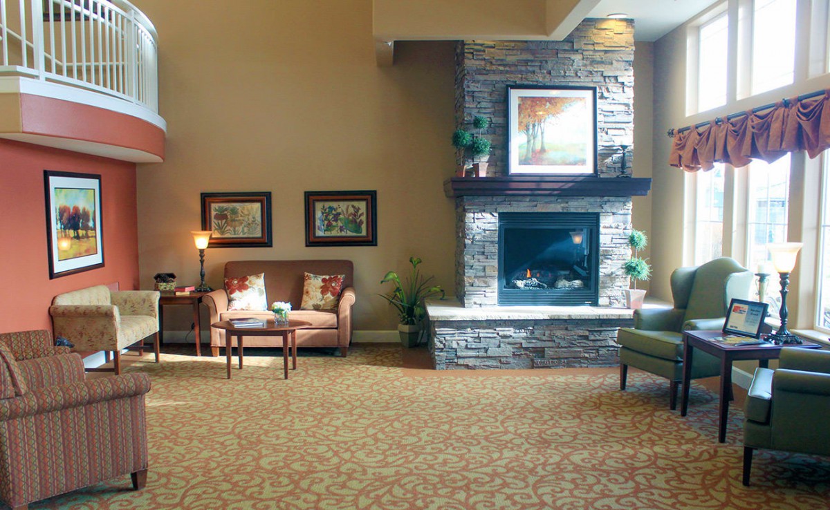 A cozy living room with a stone fireplace and comfortable seating.