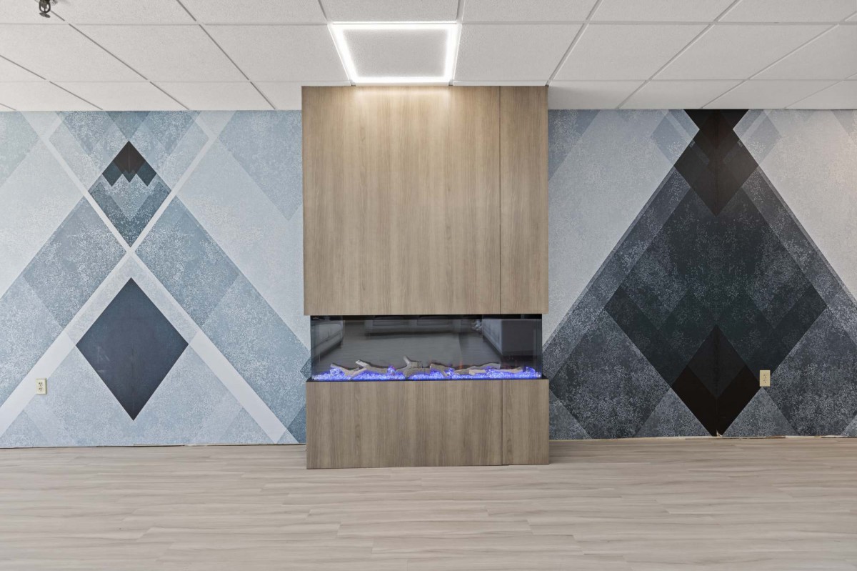 A modern interior with a sleek fireplace and geometric wall design.