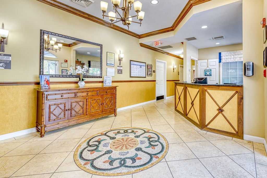A well-decorated lobby area featuring a chandelier, decorative tiled floor, and reception desk.
